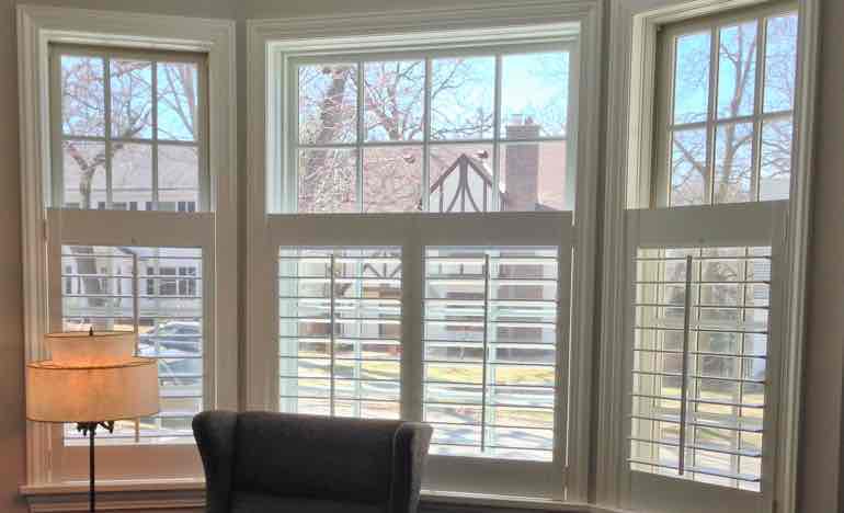 Half-length plantation shutters in family room bay window.